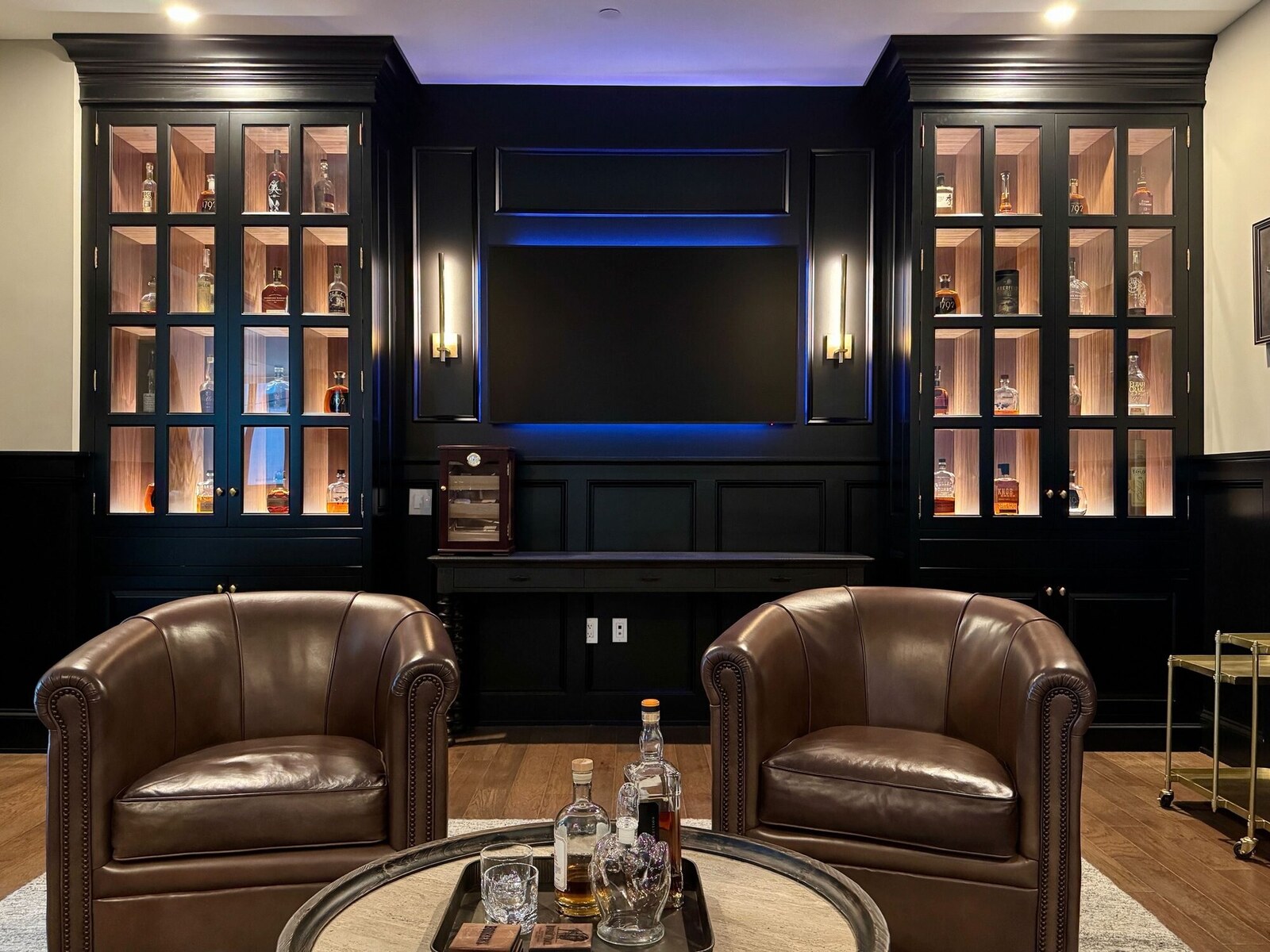 Media lounge with backlit cabinetry and integrated audio